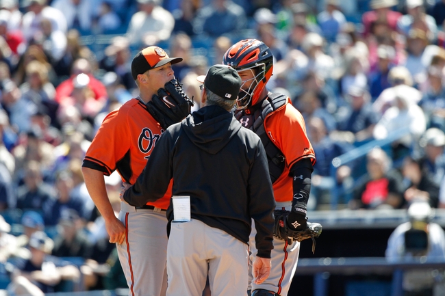 baltimore orioles catcher and pitcher huddled talking to referee