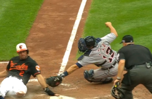 orioles player sliding into home plate with catcher tagging him