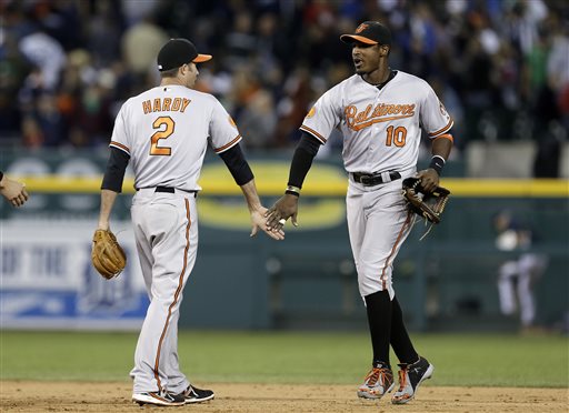orioles players jones and hardy slapping hands as jones runs by