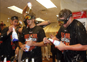 orioles players standing around locker room spraying champagne