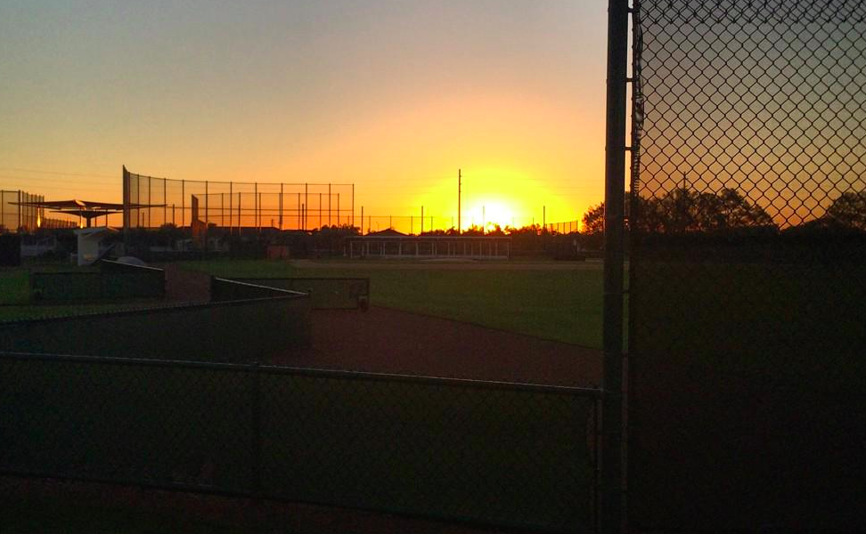 empty baseball field with sun rising