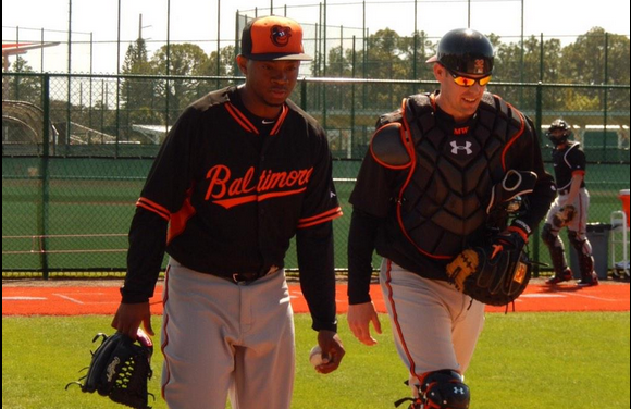 two orioles players walking together looking down