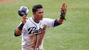 ball player holding helmet in one hand and palm up with the other