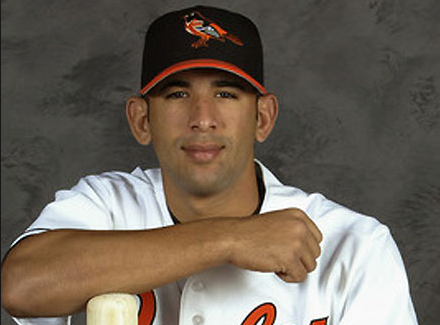 head shot of orioles player with arm resting on baseball bat