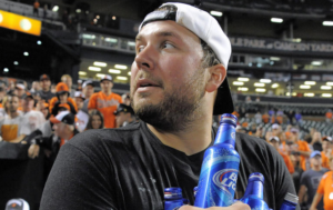 guy in stands at baseball game with multiple beers in hand