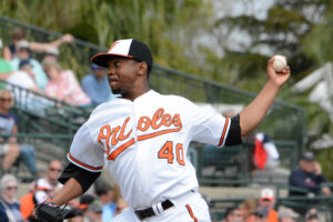 orioles pitcher with arm back during mid pitch