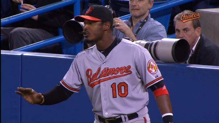 orioles player holding arm out speaking with cameras behind him