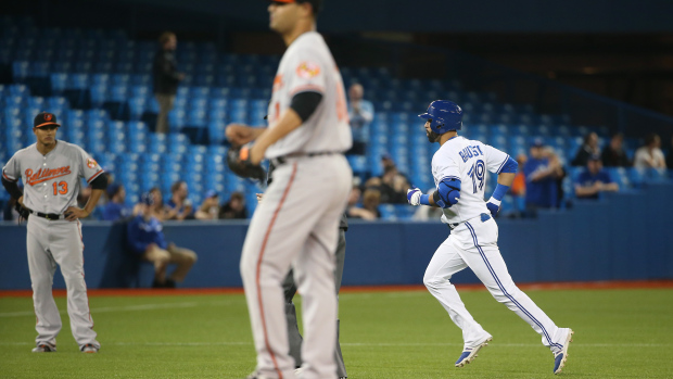 blue jays player running bases with orioles players watching