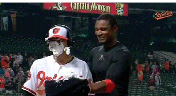 orioles player with pie on face and stadium in background