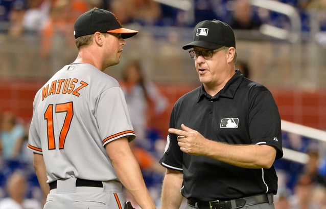 referee pointing at orioles player being ejected