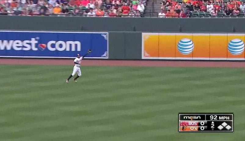 adam jones in outfield mid air about to catch a ball