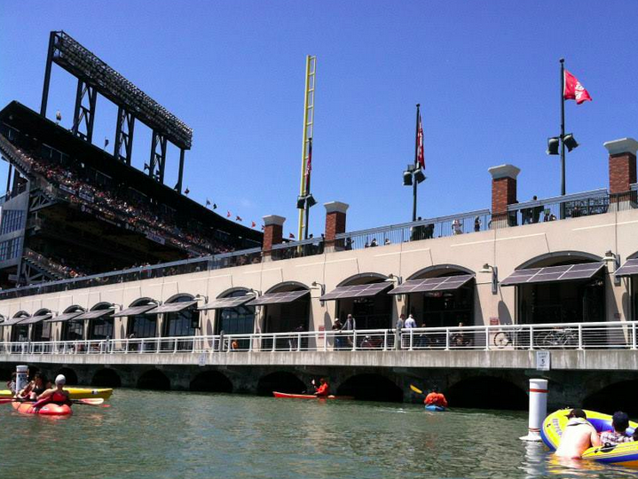 people kayaking with at&t stadium and walkway area in background