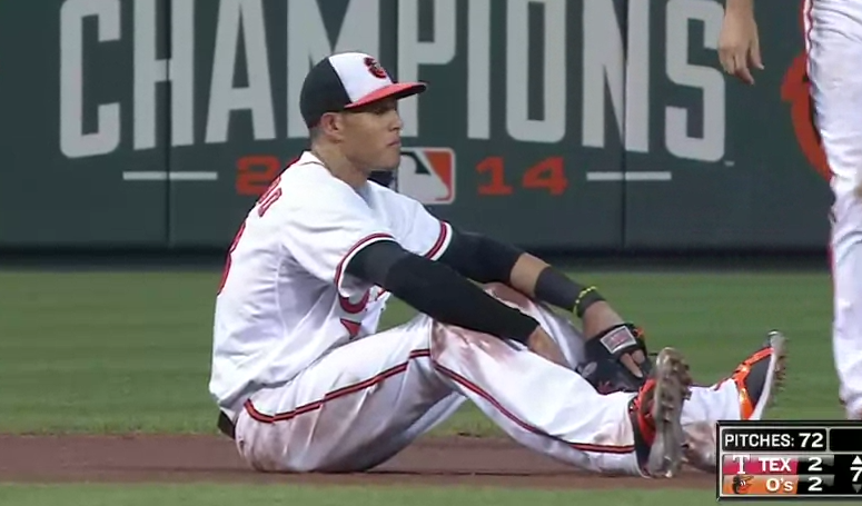 manny machado sitting on baseball field arms resting on legs