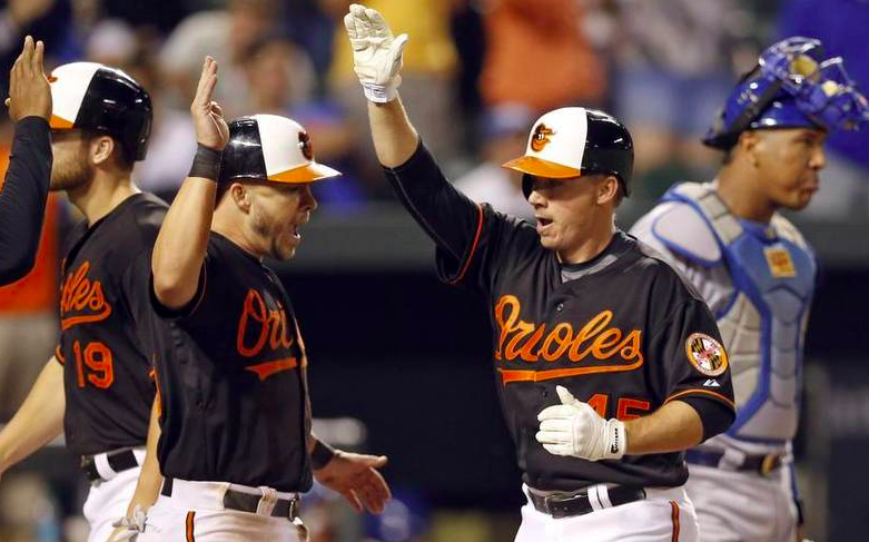 two players about to high five with royals catcher behind them