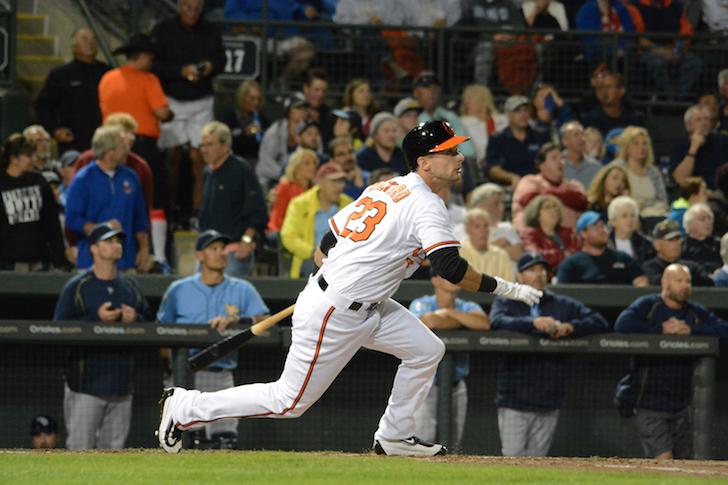 Joey Rickard runs after hitting the ball.