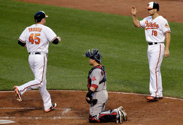 Chris Davis waits for Mark Trumbo as he crosses the plate after a home run.