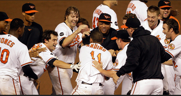 Robert Andino is mobbed after walking off the Red Sox