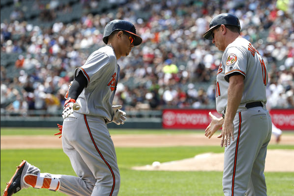 Manny Machado low-fives Bobby Dickerson as he rounds third after a home run.