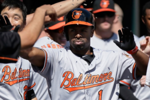 A baseball player high fives teammates in the dugout.