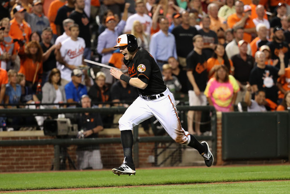 Nolan Reimold sprints toward home plate as fans cheer.