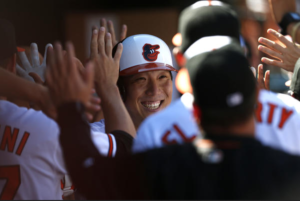 Hyun Soo Kim smiles while his teammates high five him.