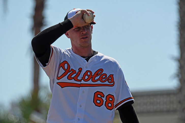 Parker Bridwell of the Orioles holds a baseball near his cap.