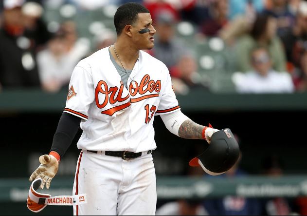Baltimore Oriole Manny Machado drops his helmet and shin guard and stares toward the pitcher's mound.