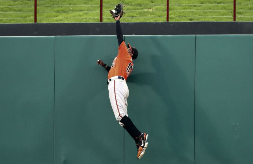 Baltimore Orioles CF Adam Jones flies high over the wall to rob a home run.