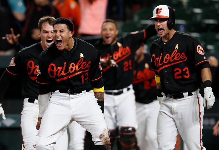 Manny Machado screams as Trey Mancini comes to join him in celebration.