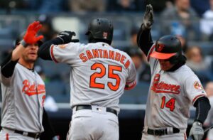 Anthony Santander, Danny Valencia, and Craig Gentry high five.