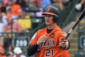 Austin Hays looks down to the 3B coach.